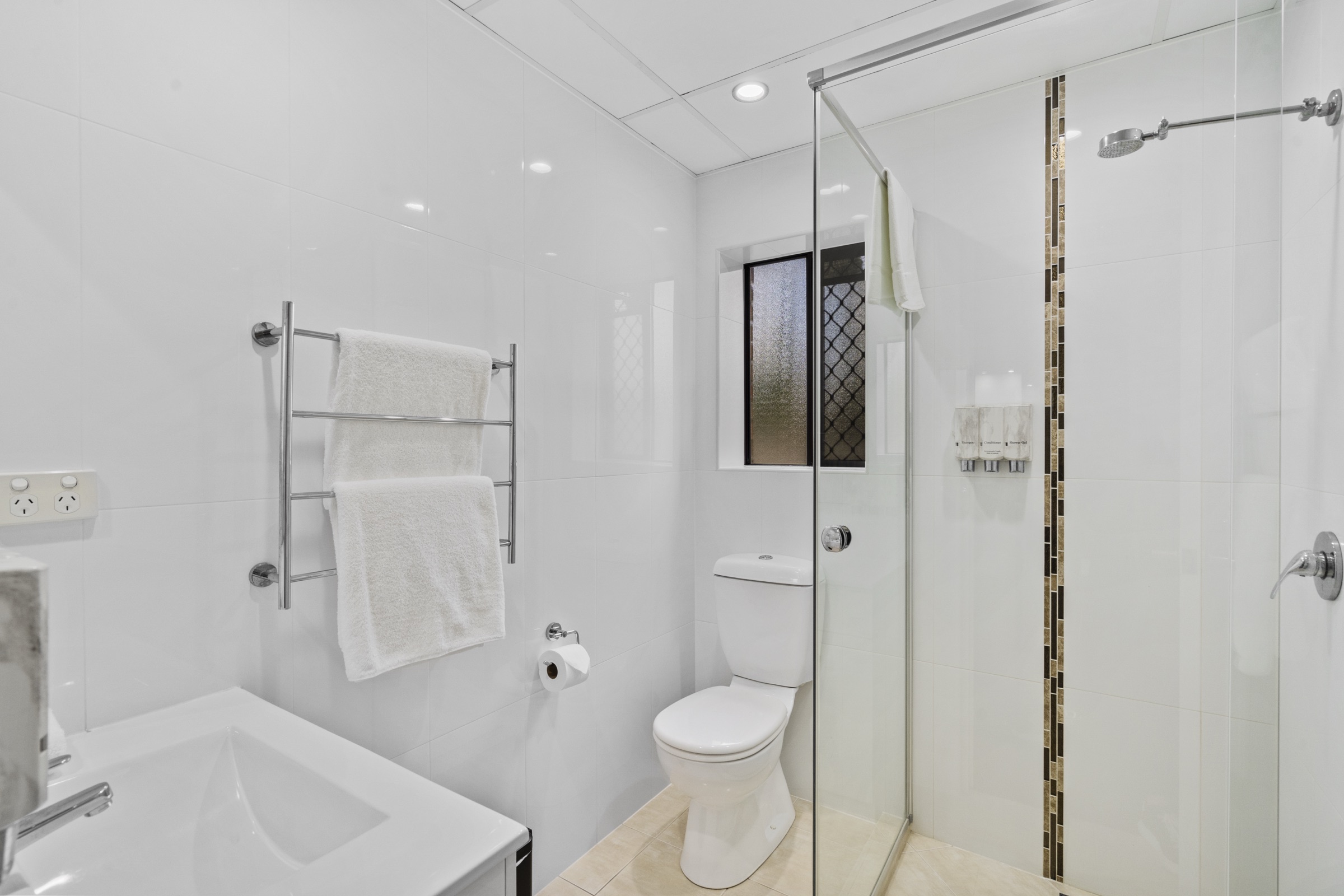 An ensuite bathroom with shower, bath and heated towel rail
