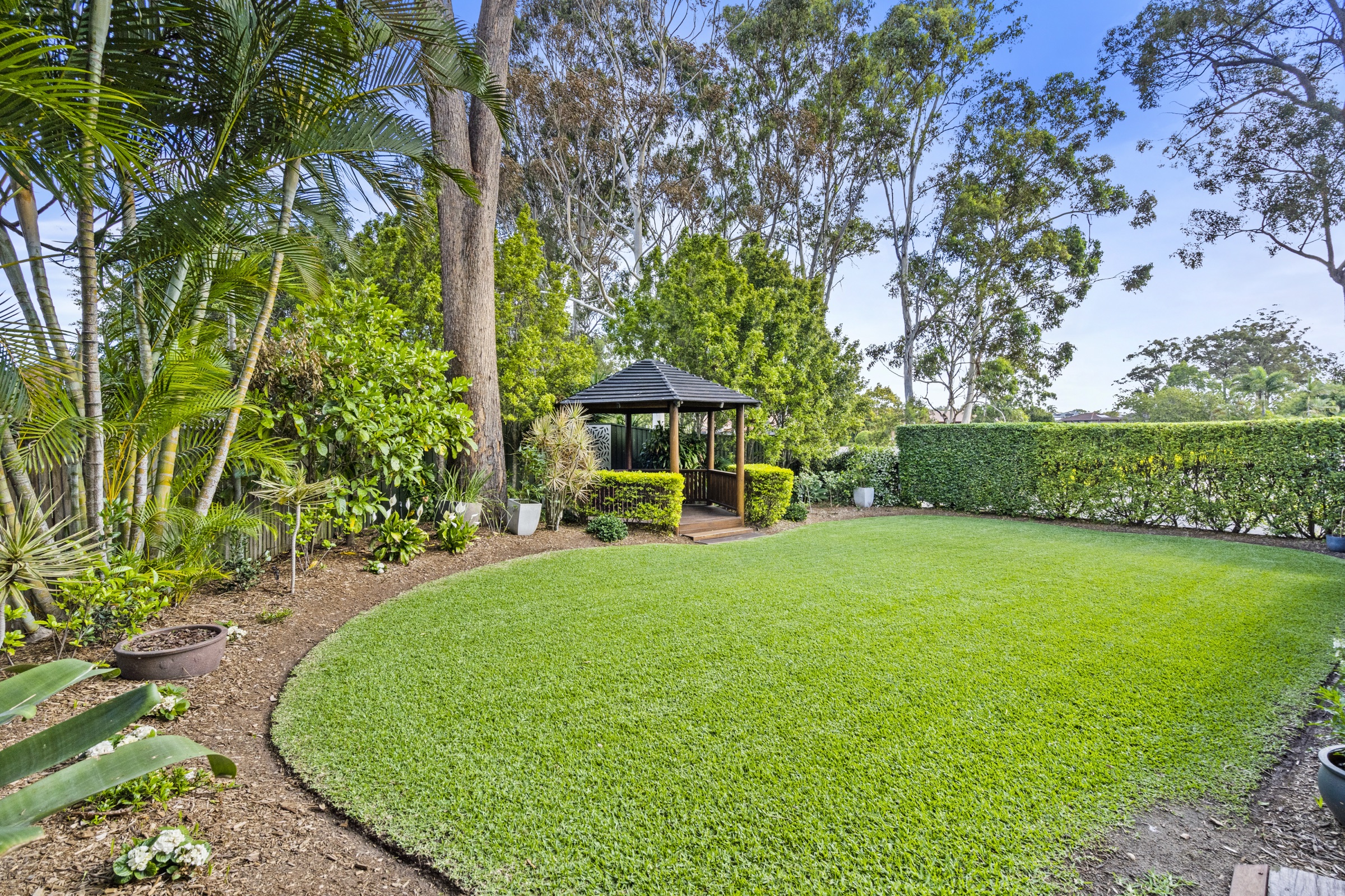 A garden lawn and rotunda among the trees, set for a ceremony