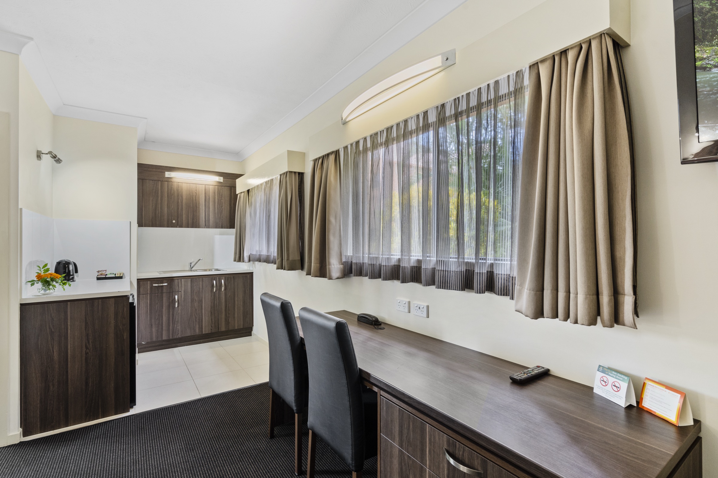 A villa room with a kitchenette, desk and garden outlook